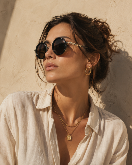 Woman in warm afternoon light wearing DayShift adaptive sunglasses, gold layered jewellery